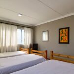 Wooden bunk beds in the 6-sleeper dorm room at Ballito Backpackers.