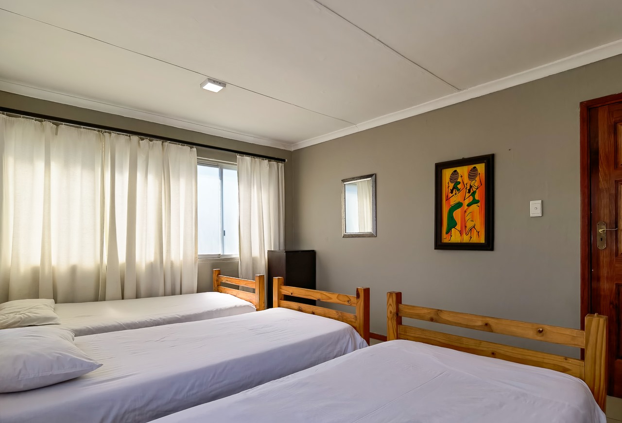 Wooden bunk beds in the 6-sleeper dorm room at Ballito Backpackers.