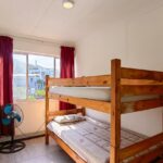 Interior of 2-sleeper dorm room with wooden bunk beds in Ballito Backpackers.