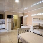 Spacious dorm room with bunk beds and kitchenette at Ballito Backpackers semi self-catering 6-sleeper room.