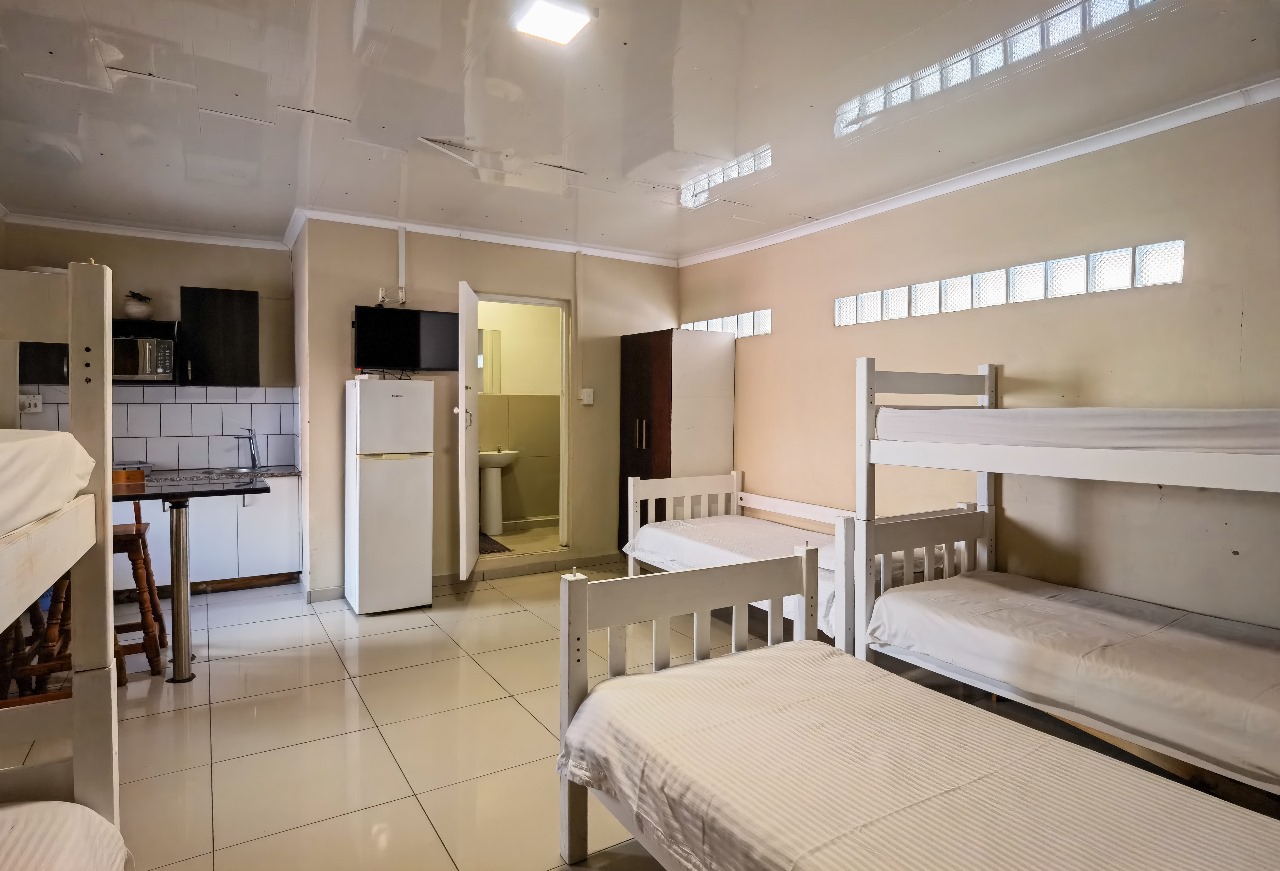 Spacious dorm room with bunk beds and kitchenette at Ballito Backpackers semi self-catering 6-sleeper room.