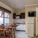 Dining area and kitchenette in the semi self-catering 6-sleeper dorm room at Ballito Backpackers.